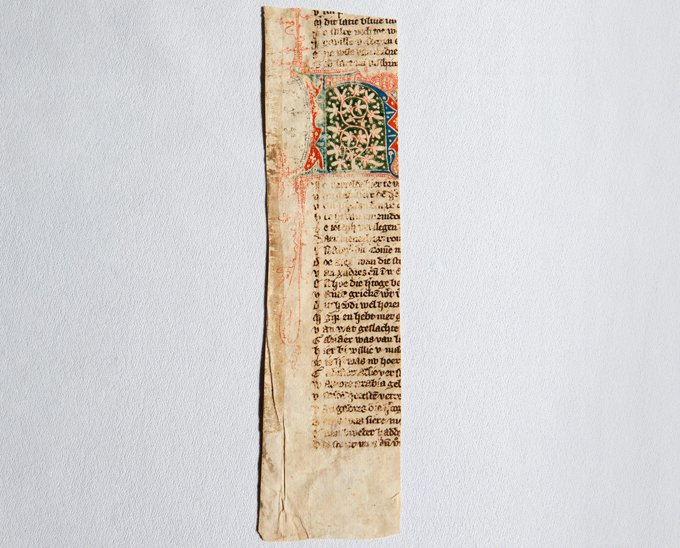 a fragment of an ancient Dutch manuscript, with a colorful image in the middle